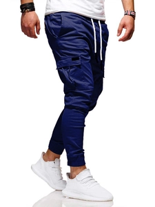 Detail view of navy blue cargo jogger pants featuring utility side pockets and white drawstrings