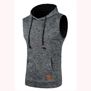 Detail of grey knitted hoodie vest featuring contrast black drawstring and leather patch