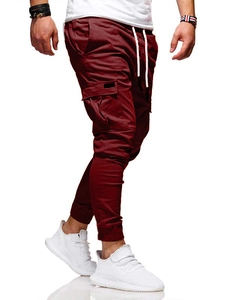 Detail of burgundy jogger pants featuring drawstring waist and functional side cargo pockets