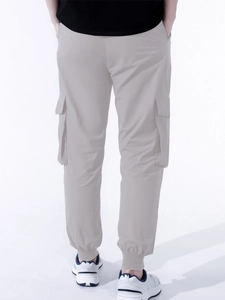 Detail of light grey cargo pants showing side flap pockets and elastic ribbed cuffs for men