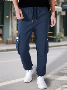 Close-up of navy blue cargo pants with drawstring waist and functional large side pockets