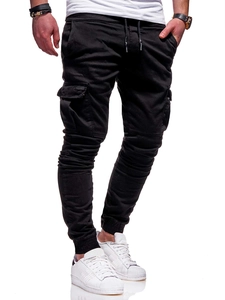 Detail view of men's black joggers featuring elastic waistband with drawstring and cargo pockets