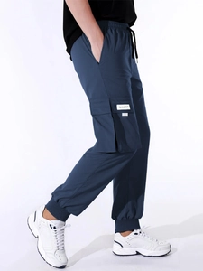 Detail of navy blue cargo joggers showing large side pockets and drawstring waist