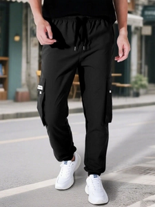 Close-up of black cargo pants featuring elastic drawstring waist and side utility pockets