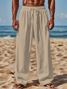 Close-up of lightweight khaki cotton linen trousers featuring elastic drawstring waist detail