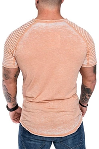 Detail view of orange acid-washed men's T-shirt with textured shoulder pleats and curved hem