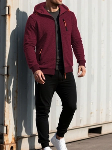 Detail of burgundy hooded jacket with textured fabric and orange zipper accents