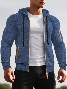 Détail d'un sweat à capuche bleu marine avec poche zippée et tirette en cuir marron
