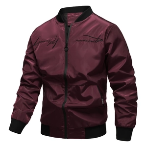 Close-up of embroidery and white fabric tag on a burgundy men's bomber jacket
