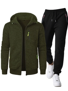 Close-up of dark green hooded jacket and black pants with contrast neon zipper detail