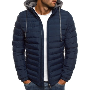 Detail of navy quilted men's jacket with gray hood and zip pockets on white background