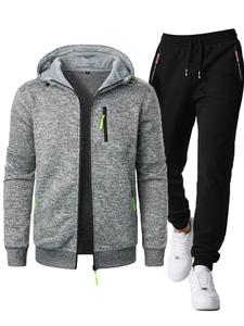 Detail of grey zip-up hoodie with neon green zipper accents and black drawstring jogger pants