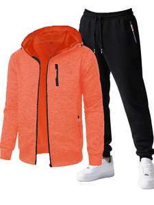 Detail of men's hooded tracksuit featuring orange zip jacket and black jogger pants