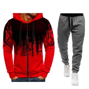 Détail du sweat à capuche rouge et noir à éclaboussures d'encre et jogging gris assorti
