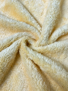 Macro shot of plush yellow fleece fabric showing thick texture and soft warmth