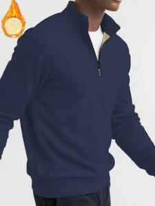 Detail of navy quarter-zip sweatshirt with golden fleece lining and sporting zipper puller