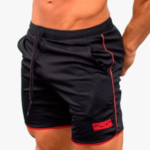 Détail du tissu en maille respirante et logo FLY rouge sur le short de sport noir pour homme