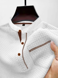 Detail showing white waffle texture fabric and brown button placket of men's polo shirt
