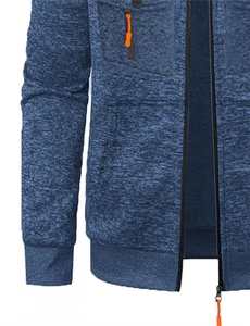 Détail du sweat à capuche en tricot bleu marine avec poche poitrine à fermeture orange