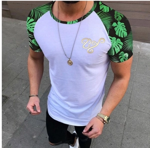 Detail eines Colorblock-T-Shirts mit tropischem Palmenmuster und goldenem Logo