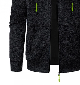 Détail du cardigan en maille gris foncé avec zips vert fluo et texture côtelée moderne