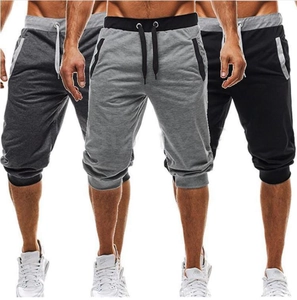 Close-up of men's athletic shorts in grey and black with drawstring waist and zip pockets