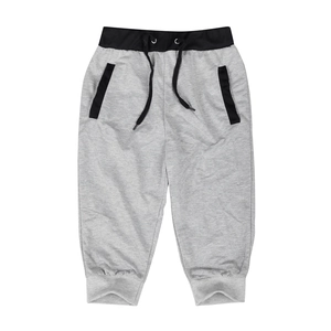 Detail view of grey knit joggers featuring black elastic waistband and zippered side pockets