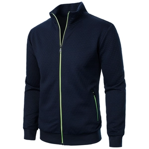 Detail of dark blue jacket with neon green zipper contrast and textured fabric