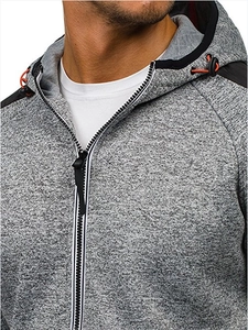 Détail d'un sweat à capuche gris chiné pour homme avec zip noir et cordons rouges