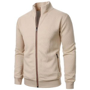 Detailed view of beige zip-up jacket featuring diamond textured fabric and ribbed cuffs