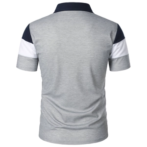 Detail view of the grey polo shirt back showing navy and white spliced sleeve stitching