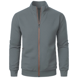 Detail of grey stand collar jacket featuring geometric jacquard texture and orange zipper accent
