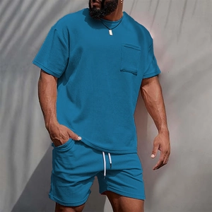 Detail view of blue corduroy texture on men's t-shirt pocket and drawstring shorts set