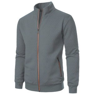 Detail of grey men's jacket with textured jacquard fabric and orange zipper