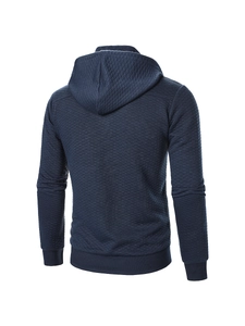Detailansicht des dunkelblauen Herren-Hoodies mit Rautensteppmuster und Rippbündchen