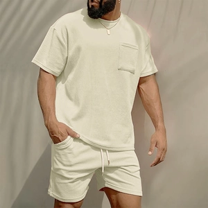 Detail of men's beige corduroy set showing ribbed fabric texture and chest pocket design
