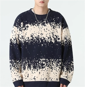 Close-up of men's navy knit sweater with beige pixelated stripe pattern and crew neck