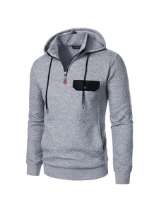 Detailansicht grauer Stepp-Hoodie mit Rautenmuster und schwarzer Brusttasche