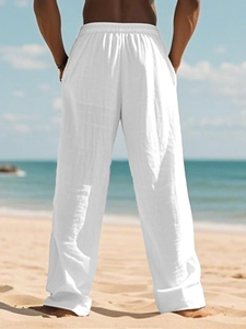 Rear view of white linen beach pants for men featuring an elastic waist and loose fit