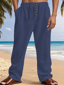 Close-up of men's navy cotton linen beach pants with drawstring waist and button fly details