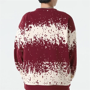 Detail of burgundy and cream pixelated pattern on loose fit knitted men sweater