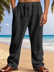 Detail of drawstring waist with brown wooden buttons on men's linen beach trousers