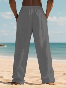 Detail of loose fit dark grey cotton linen trousers with elastic drawstring waist