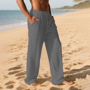 Detail of men's grey linen casual pants with drawstring waist on the beach