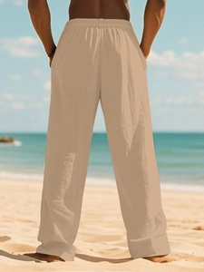 Rear view of khaki breathable cotton linen trousers for men with elastic waistband on a beach