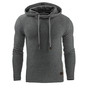 Detail of gray men's hoodie featuring textured jacquard fabric and a brown leather patch