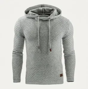 Detail of grey men's hoodie showing thick brick-patterned knit texture and leather hem tag