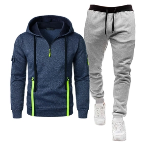 Détail du sweat à capuche marine avec bordure vert fluo, demi-zip et poche sur la manche