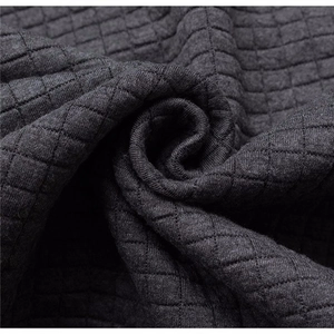 Detailed view of dark grey knitted fabric with 3D square quilted texture for winter hoodie