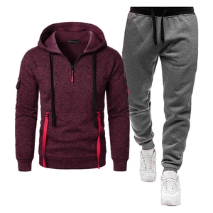 Détail d'un sweat à capuche bordeaux à demi-zip et d'un pantalon de jogging gris foncé